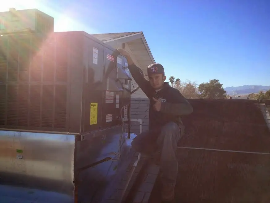 HVAC technician performing HVAC Inspection on a rooftop unit in Huntington